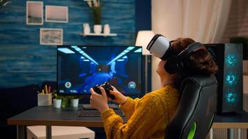 Professional gamer wearing virtual reality headset using wireless controller. Pro esport team player streamer playing gaming tournament on powerful RGB computer, using modern streaming technology photo
