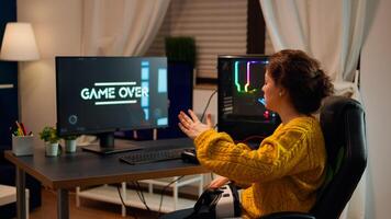 Gamer woman losing videogame tournament while playing with VR headset using joystick controller and headset late at night. Virtual shooter game championship in cyberspace, esport player gaming photo