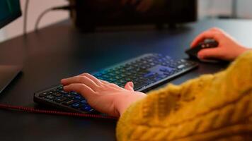Close-up on woman hands gamer playing game using RGB keyboard during virtual championship in cyberspace. Online streaming cyber performing on powerful personal computer during gaming tournament photo