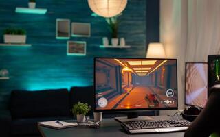 Close up of empty gaming home studio with neon lights equipped with professional powerful computer, headphones, RGB keyword, mouse photo