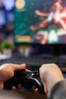 Closeup of competitive player holding joystick playing space shooter games at powerful computer late night. Professional gamer using controller for online championship sitting on gamining chair photo
