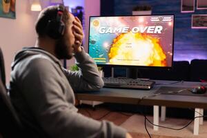 Professional gamer man playing space shooter game on computer for championship. Cyber performing on powerful pc in gaming room home during online tournament photo