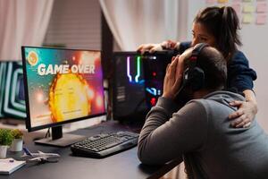 Side view of game over for pro player couple, playing space shooter games. Defeated man streaming online cyber performing during gaming tournament photo