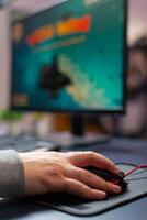 Close up hand of pro gamer in home studio using professional mouse, streaming online gaming tournament. Playing virtual first space shooter game photo