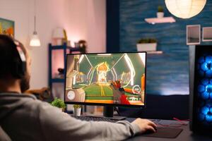 Pro virtual gamer wearing headphones playing games at professional computer late night. Online streaming cyber performing during gaming tournament using technology network wireless photo