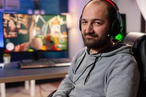 Competitive gamer looking into powerful computer playing online shooter game late at night with vr headset and wireless console . Virtual online streaming cyber performing during game tournament photo