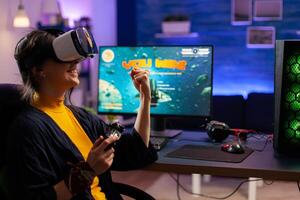 Videogamer woman win space shooter game using virtual reality goggles playing games with modern joypad. Professional gamer streaming online videogames with new graphics on powerful computer photo