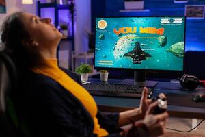 Gamer winning space shooter online tournament using professional controller and powerful computer. Pro player streaming online game new graphics in gaming home studio photo