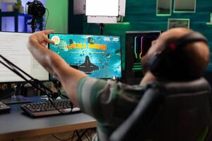 Concentrated streamer playing space shooter game using modern headset . Online streaming cyber performing on powerful professional computer during gaming tournament photo