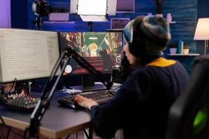 Esport streamer playing shooter game with other players on streaming chat for virtual games competition. Gamer making online videogames with new graphics on powerful computer photo