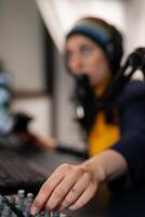 Close up of streamer wearing headset and talking into microphone with streaming comunity using professional mixer. Pro gamer playing online videogames with new graphics on powerful computer photo