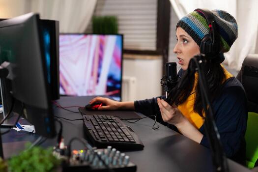 Caucasian pro streamer talking into professional microphone for virtual competition in gaming home studio. Gamer playing online videogames with new graphics on powerful computer photo