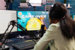 Game over for esport african strategy player during tournament live. Professional gamer streaming online games with new graphics on powerful computer. photo