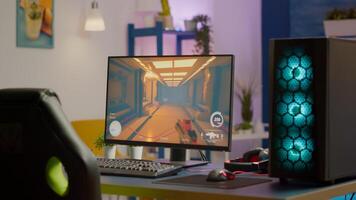 Gaming room no people in equiped with RGB powerful personal computer for online videogames tournament and gaming chair, first-person shooter game on screen. Cozy room with neon light. photo