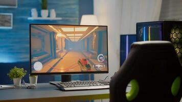 Empty cyberspace with RGB powerful personal computer with first-person shooter game on screen in gaming studio with no people at desk prepared for online esports tournament. Room with no people photo