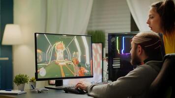 Couple of gamers playing first person shooter videogame on RGB powerful computer screaming, supporting each other during online competition. Pro cyber man performing from home at virtual tournament photo
