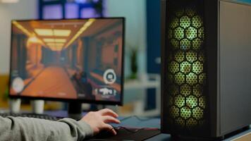 Close up of RGB powerful computer gamer rig with first-person shooter game on screen, pro cyber man participating at online esports championship. Player performing at gaming tournament in cyberspace photo