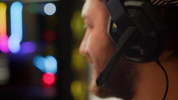 Close up of pro man streaming FPS shooter game on powerful computer during online gaming championship, talking into headset. Esport cyber team of gamers play in mock-up virtual videogame. photo