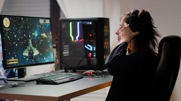 Professional esport woman gamer coming in gaming room playing space shooter game during online championship event. Streaming cyber performing on powerful computer during virtual tournament photo