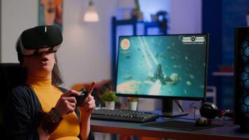 Player woman wining space shooter game using virtual reality goggles playing games with modern joystick. Professional cyber gamer streaming online games with new graphics on powerful computer photo