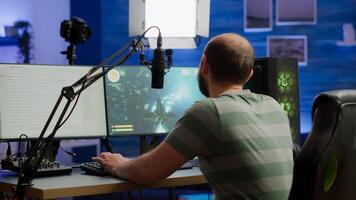 Streamer cyber performing space shooter game on RGB powerful computer talking with players on stream chat and microphone during professional competition. Player man streaming in home studio photo