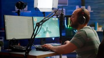 Competitive gamer with headphones using stream chat on powerful computer playing online shooter game late at night. Virtual online streaming cyber checking sound performing in gaming tournament photo