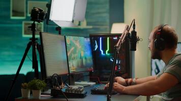 Competitive player streaming esport tournament checking sound mixer, stream chat and professional microphone. Competitive man playing online space shooter gaming competition on powerful computer photo