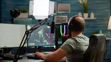 Excited streamer with headphones winning important online esport competition of space shooter playing on powerful computer. Professional pro gamer streaming videogames using professional microphone and headset photo