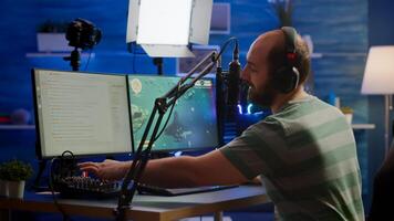 Man streamer cyber checking sound at mixer performing space shooter game on RGB powerful computer talking with players on stream chat and microphone in gaming competition. Player man streaming photo