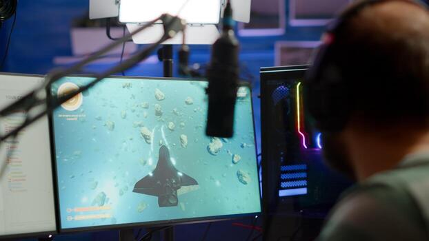 Close-up of streamer man talking at microphone with other players during space shooter tournament. Online streaming cyber performing games competition using technology network wireless photo