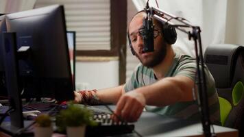 Professional man streamer preparing for virtual gaming tournament checking sound mixer playing from home studio at RGB powerful computer. Cyber gamer performing at online esport championship photo