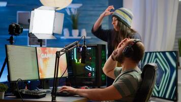 Nervous players couple losing online videogames competition using powerful computer screaming at each other. Streamer gamer playing games with RGB keyboard performing at gaming turnament photo
