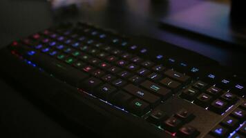 Close-up of professional keyboard with RGB lighting during online gaming tournament. Home studio of esport game player using powerful gaming PC photo