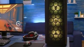 Close-up of RGB system desktop, pro gamer playing first person shooter game during online competition. Streaming studio is equipped with professional setup with powerful pc ready for online game photo