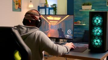 Addicted game r performing cyber games using professional headphones in gaming room. Competitive gamer playing game tournament with new graphics on powerful computer. photo
