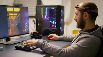 Cyber gamer playing esport shooter game for virtual tournament on powerful computer using RGB keyboard and professional mouse. Player streaming online games in gaming home studio. photo