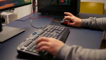 Closeup of player hands using RGB keyboard in gaming home studio. Digital gamer using professional equipment for first shooter game person competition late at night in living room photo