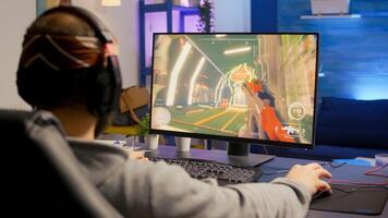 Professional player with headphones performing first person shooter game with modern graphics at virtual championship. Online streaming cyber using technology network wireless photo