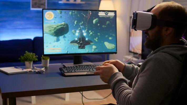 Competitive gamer winning space shooter games championship wearing virtual reality goggles. Pro cyber professional playing with joypad during online tournament using technology network wireless