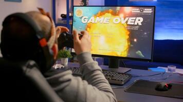 Competitive cyber pro gamer losing online game tournament wearing professional headset. Pro player using joypad for space shooter championship sitting on gamining chair photo