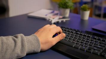 Closeup of gamer typing on professional RGB keyboard, playing online game in gaming home studio. Player using modern equipment streaming e-sport competition late at night photo