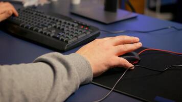 Close-up on hands of player man using professional RGB mouse and keyboard. Digital gamer using professional equipment for first shooter game person competition late at night in living room photo