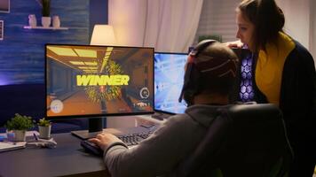 Back shot of excited couple, esport gamer winning virtual tournament game using RGB equipment. Winner man playing online first person shooter competition with powerful professional computer photo