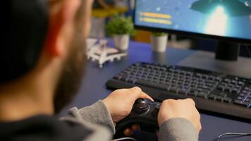 Close-up of gamer playing first person online competition using professional wireless controller. Pro player use joypad for digital championship sitting on gamining chair late at night in living room photo
