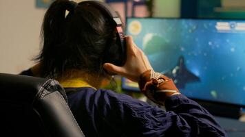 Cyber gamer playing space shooter game using RGB keyboard and professional headset during gaming tournament. Player talking with multiple players using headphones while streaming games photo