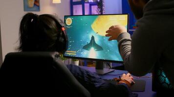 Couple of gamers playing multiplayer game on powerful computer at home with professional headphones. Online streaming cyber performing during gaming tournament using technology network wireless photo