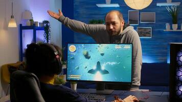 Woman gamer playing space shooter game and fight with her boyfriend about online tournament. Competitive player streaming game tournament using professional equipment at home gamming studio photo
