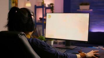 Concentrated gamer woman losing virtual multiplayer game on powerful computer at home with professional headphones. Digital gamer using RGB equipment for shooter space gaming competition late at night photo