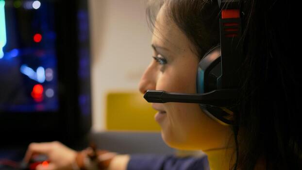 Close-up portrait of pro gamer playing online space shooter for digital competition. Player talking into microphone with multiple players using headset during gaming tournament photo