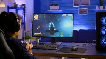 Pro gamer playing space shooter online championship with modern graphics using wireless controller. Competitive player streaming game tournament using professional equipment at gaming studio photo